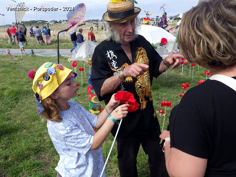 RIMG0863.JPG - Sophie aide Claude Lebourgeois qui offre des coquelicots au public ! Découvrez quelques facettes des bénévoles dans la galerie suivante !